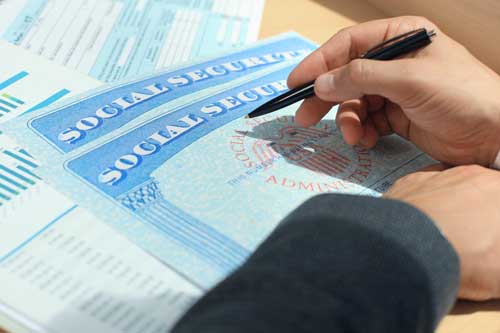 close-up of hand signing a Social Security form.