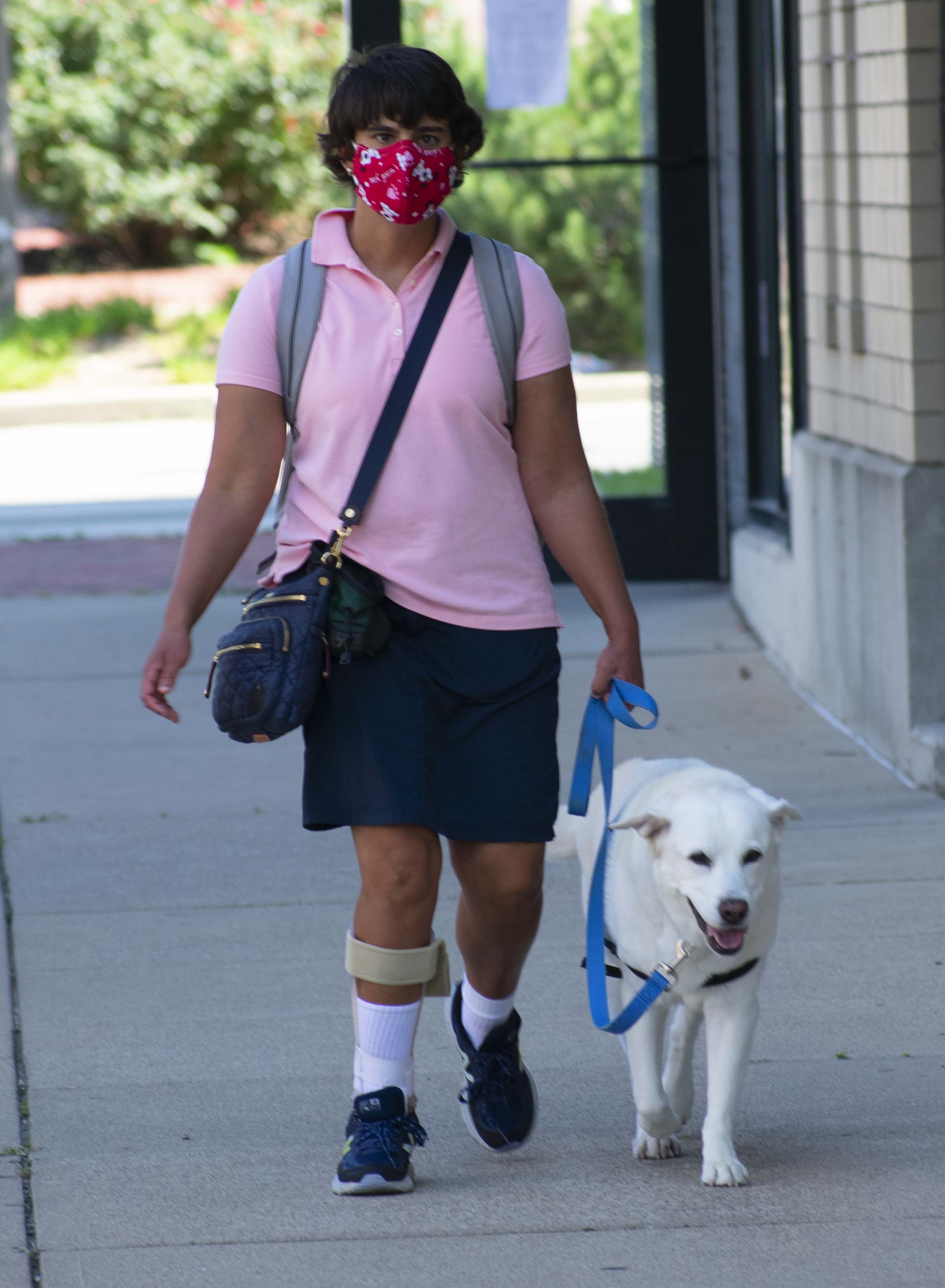 Adria and Lucy walking on a sidewalk in town. 