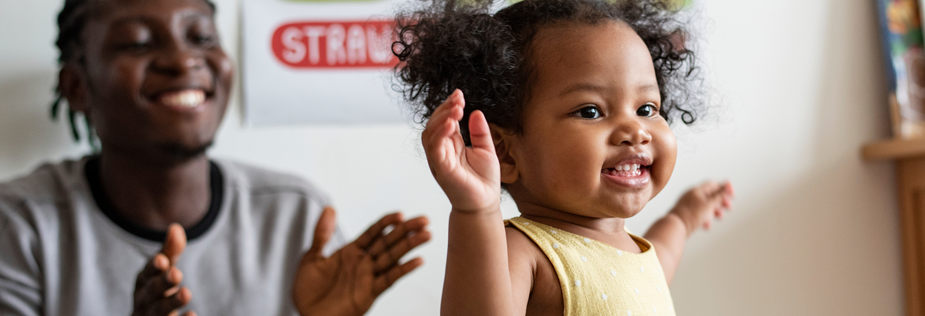 Parent cheering on happy toddler.