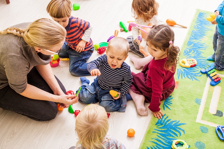 Preschool teacher helping upset students.